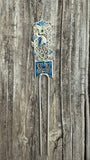 Decorative hairpin with blue and silver design on a wooden background